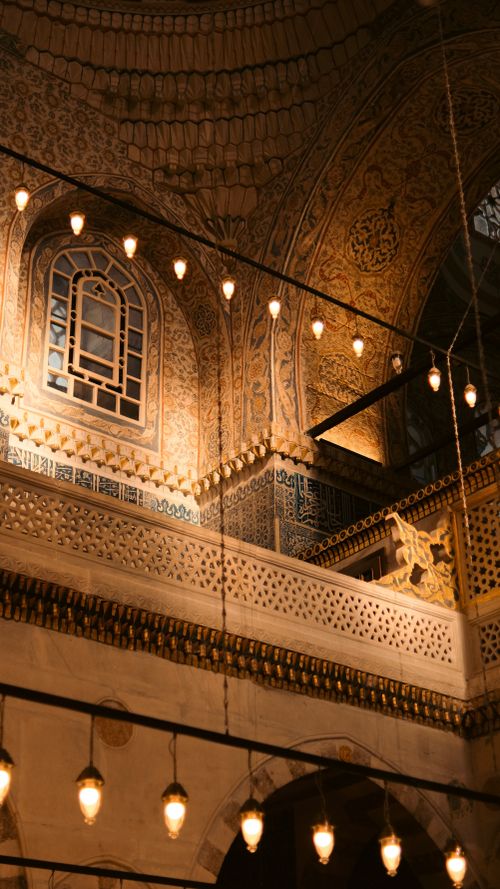 Free Intricate mosque interior showcasing ornamental walls and hanging lights, highlighting Islamic architectural beauty. Stock Photo