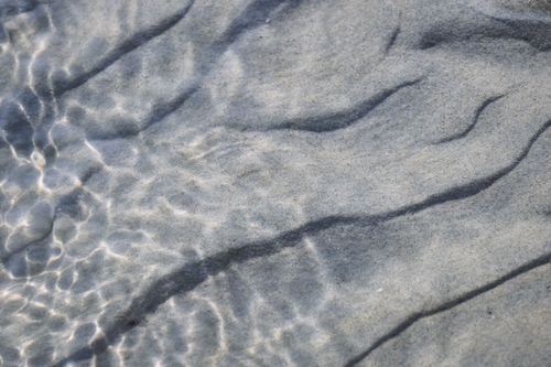 Free A close-up view of sand patterns under shallow water at Domburg beach. Stock Photo