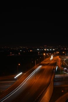 A captivating night view of city streets with vibrant light trails and urban skyline.