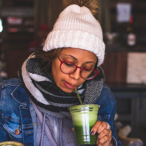 Selective Focus Photography of Woman Sipping from Disposable Cup