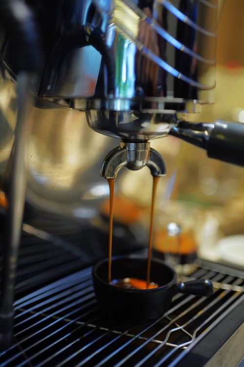 Free Close-up of espresso pouring from machine in Nagpur cafe, showcasing brewing process. Stock Photo
