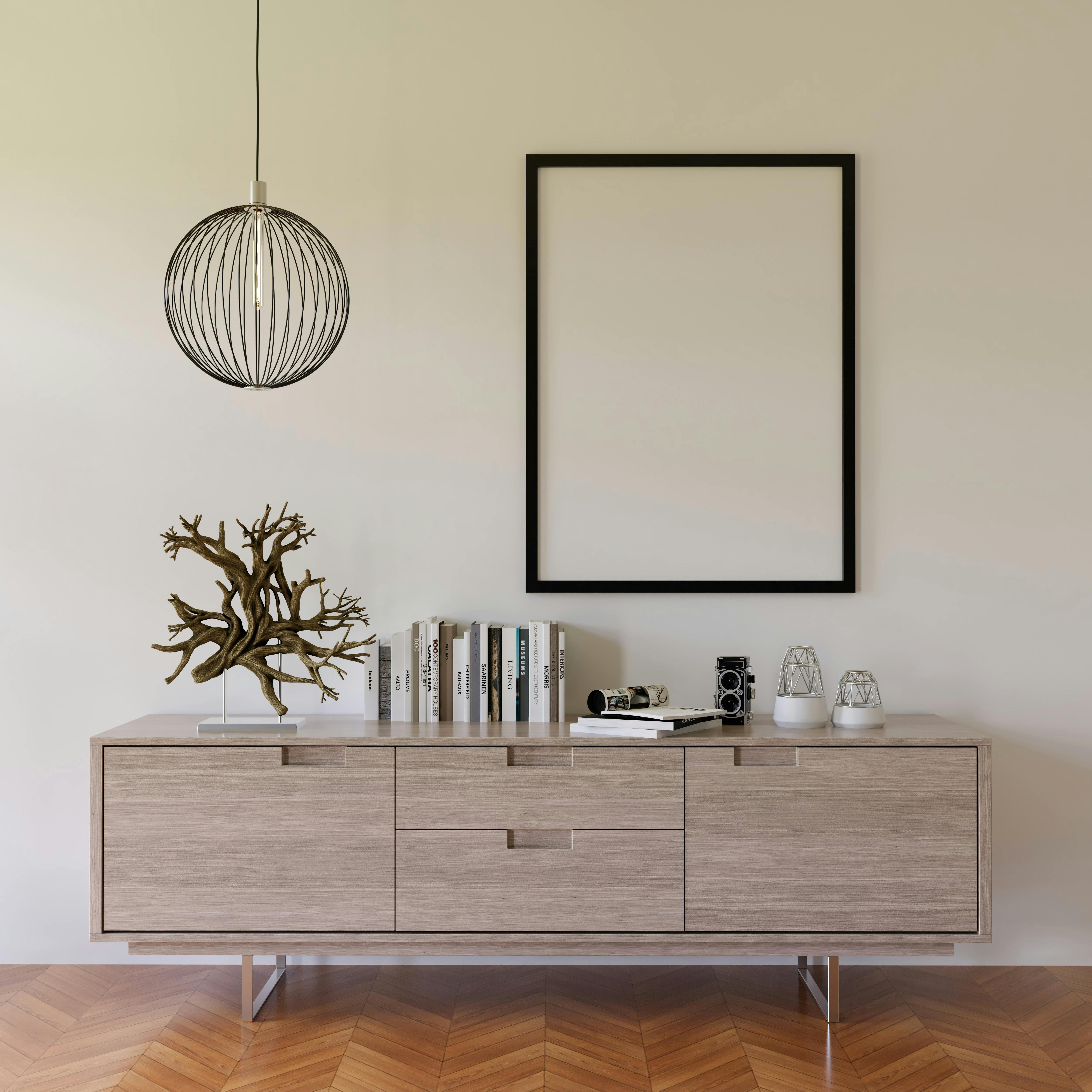 Stylish minimalist interior featuring a credenza, pendant lamp, and empty frame.