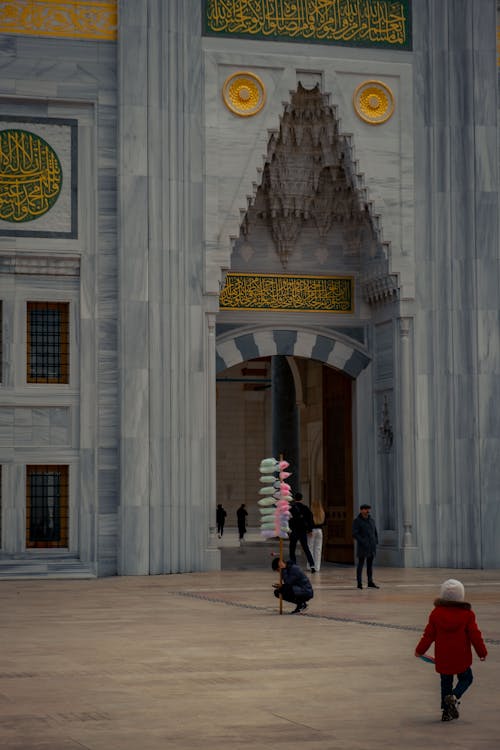 A woman walking with a child in front of a building