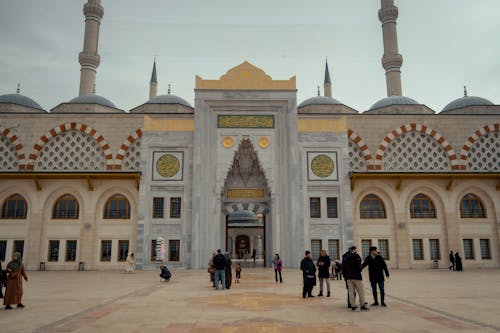 People walk around the outside of a mosque