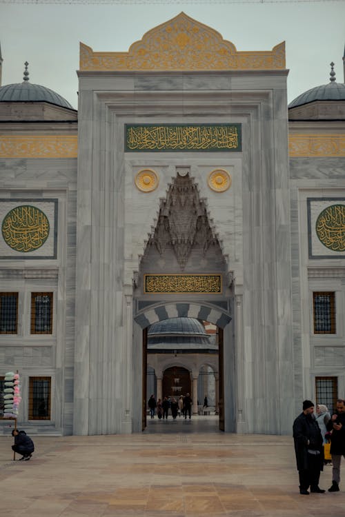 A large building with a large entrance and two people walking