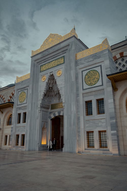 The entrance to a mosque with a clock on it