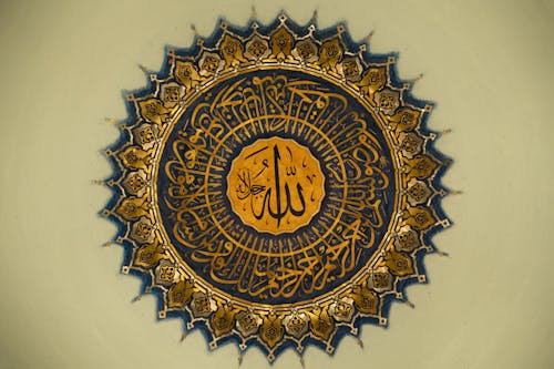 A large gold and blue islamic calligraphy on a wall
