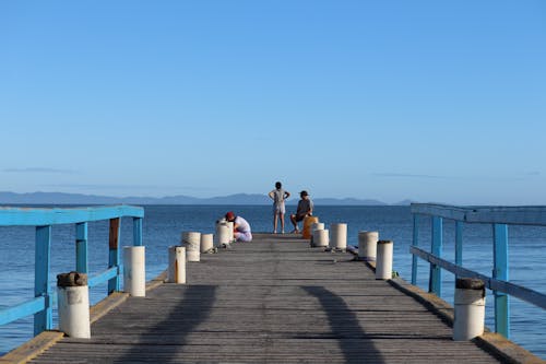 A pier with people walking on it and a blue sky