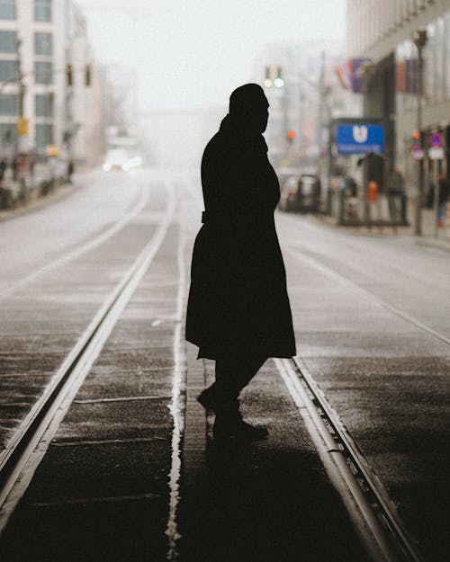 A woman in a coat walks down a street
