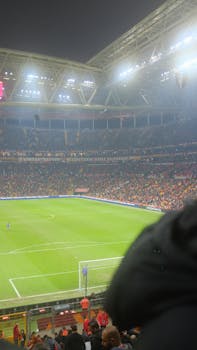 Crowded stadium during a night soccer match, filled with energetic fans and bright lights.