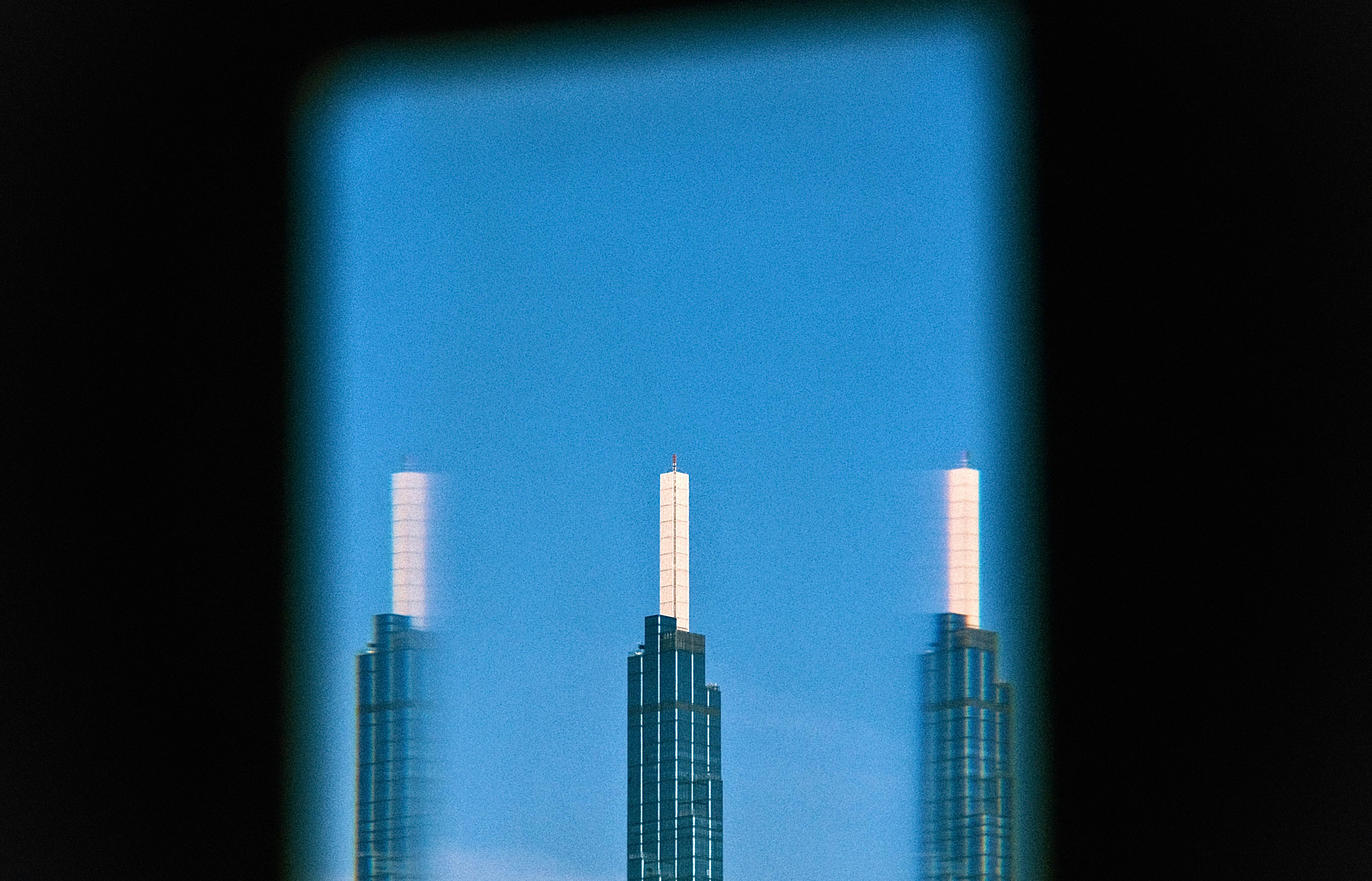Artistic reflection of Landmark 81 skyscraper in Ho Chi Minh City against a clear blue sky.