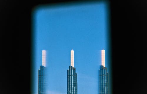 A view of two tall buildings through a window