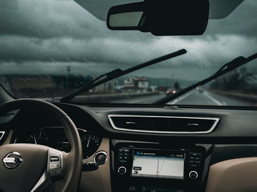 A dashboard view of a car with windshield wipers