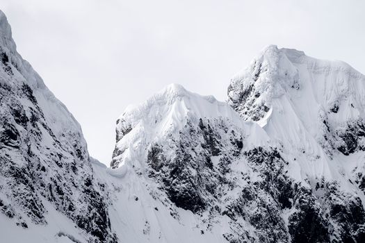 Dramatic snowy mountain peaks under a clear winter sky, showcasing nature's beauty.