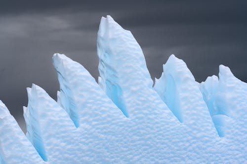 A close up of a large iceberg with snow on it
