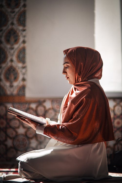 Woman in Headscarf Holding Koran