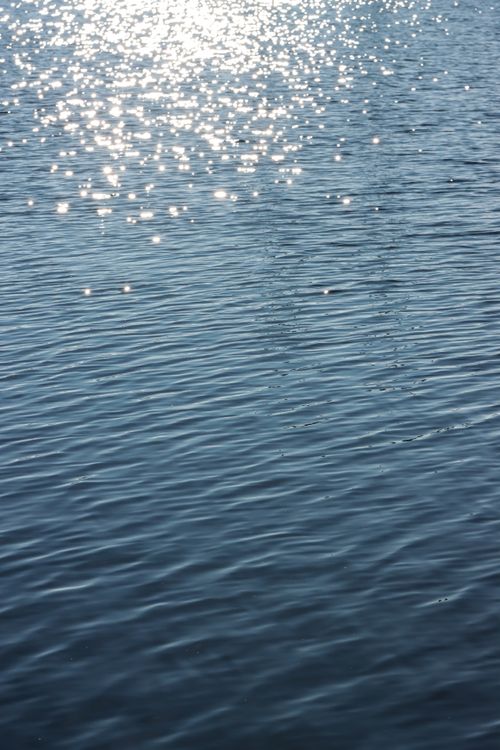 Free Sunlit sparkles dancing on a tranquil lake in Jönköping, Sweden. Stock Photo