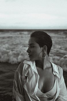 Stylish woman with short hair enjoying a day at the beach in grayscale.