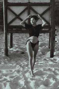 Stunning black and white photo of a woman enjoying the sun on a sandy beach.