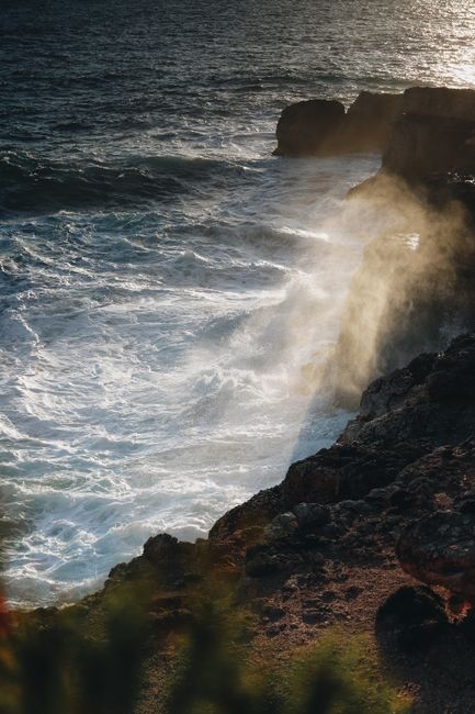 Dramatic waves crash against rocky cliffs at sunset on the Spanish coast, IB.