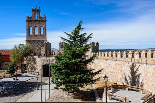 Explore the medieval walls and tower of Ávila, Spain, under bright sunlight.
