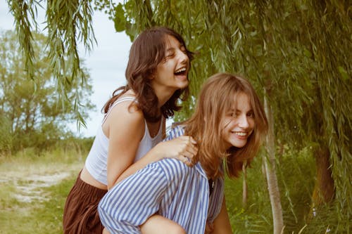 Two women are standing next to each other in the woods