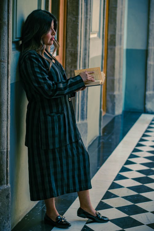 A woman in a black and white dress is standing on the floor