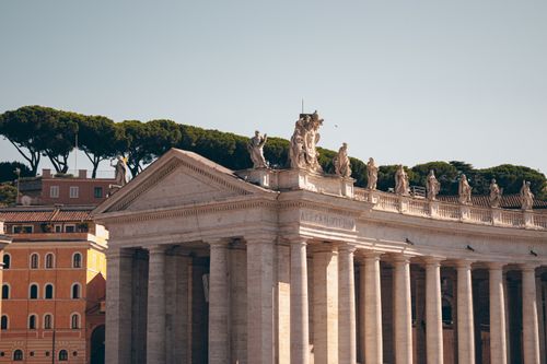 Explore the grandeur of Vatican City's architecture with majestic columns and statues.