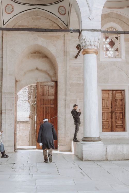 Free People by a mosque doorway in Istanbul, showcasing its rich historical architecture. Stock Photo
