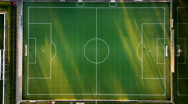 Aerial drone shot of a well-maintained soccer field in Hoogeveen, Netherlands at sunset.