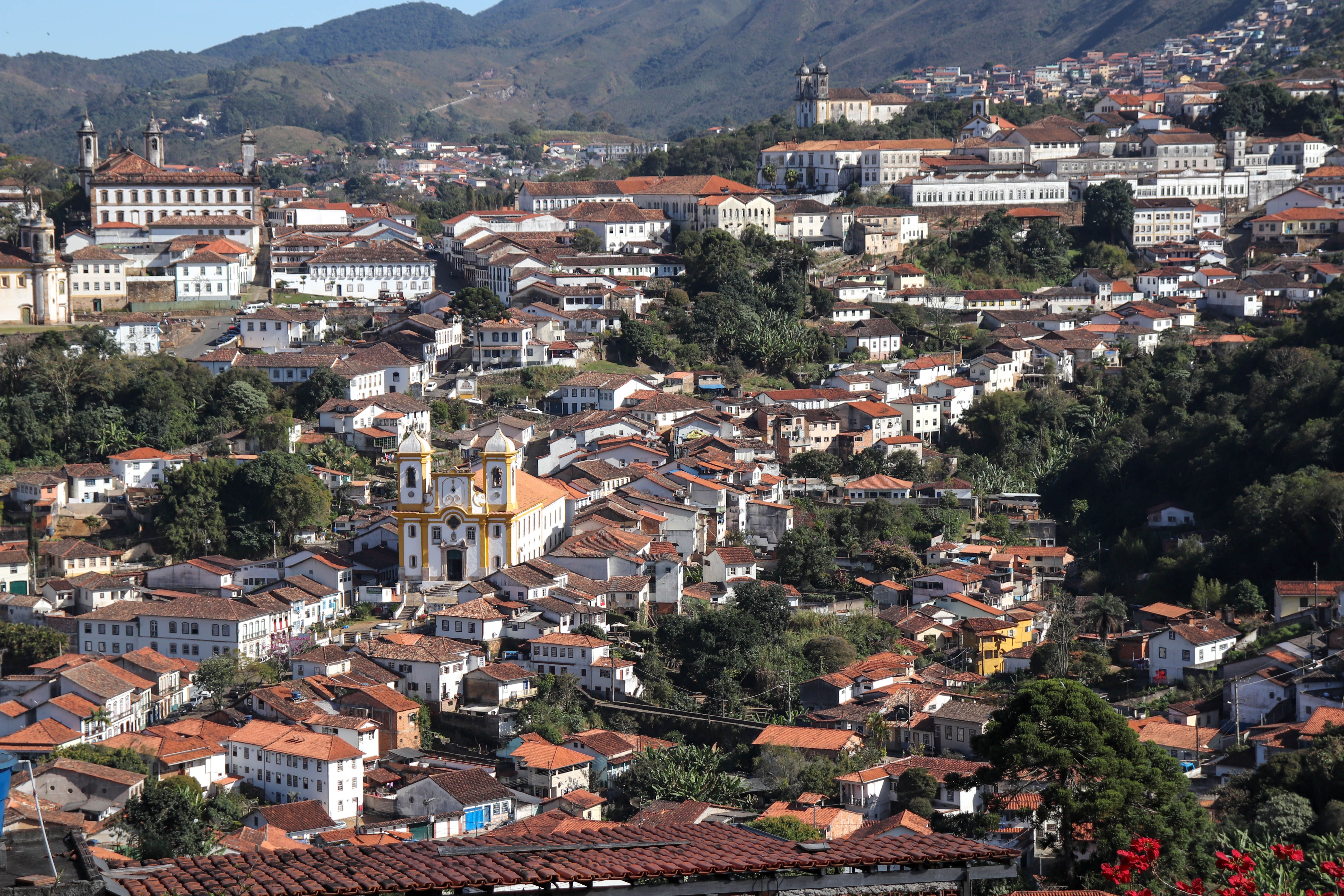 Aerial shot of Ho town with green hills and a church building in the foreground, drums visible through open windows