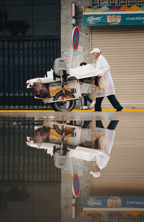 Street Vendor in a White Coat Pushing an Ice Cream Cart