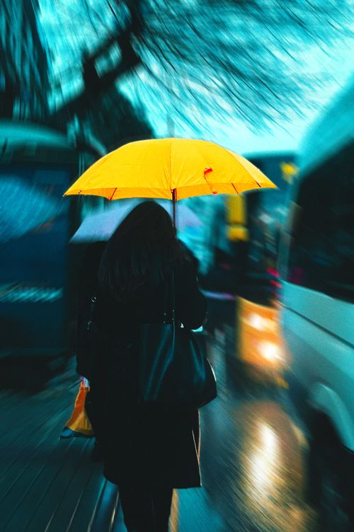 Free A woman with a yellow umbrella walking on a rainy city street in Istanbul. Stock Photo
