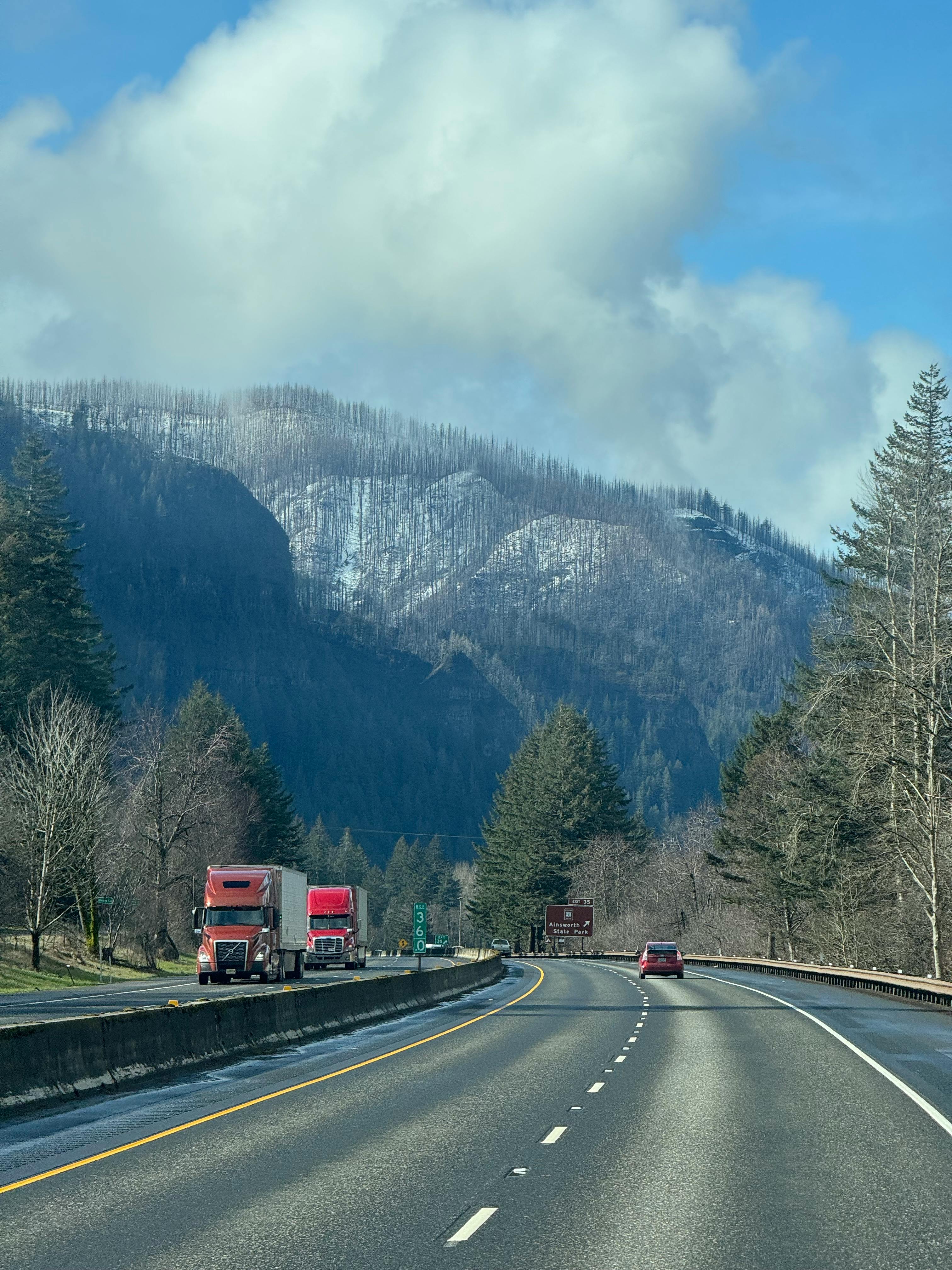 Trucks on highway with forest background &mdash; red flags when choosing a factoring company