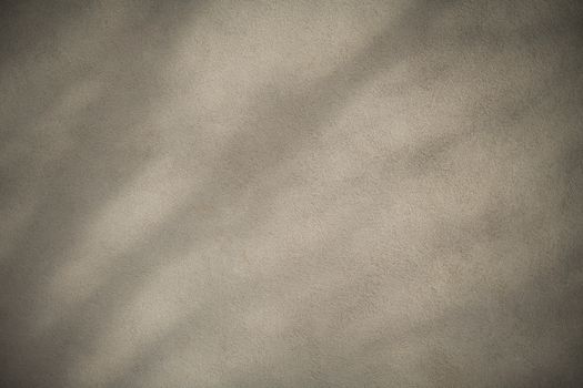 A textured gray wall showcasing light and shadow patterns creating a subtle abstract effect.