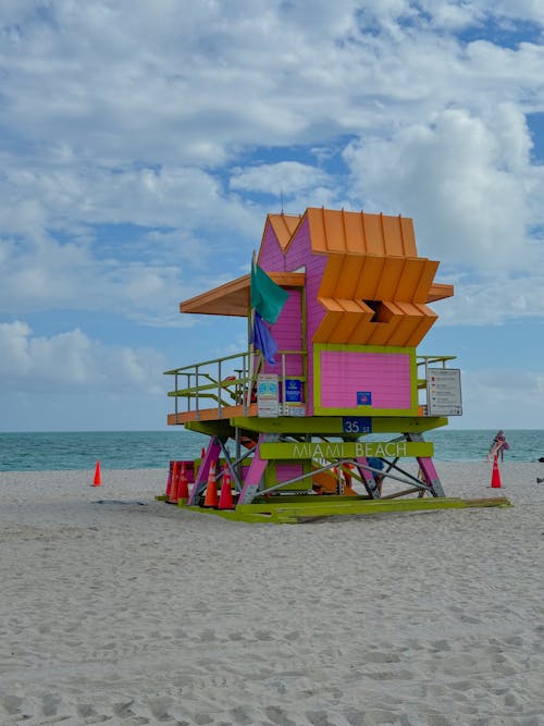 A lifeguard tower on the beach with a colorful roof