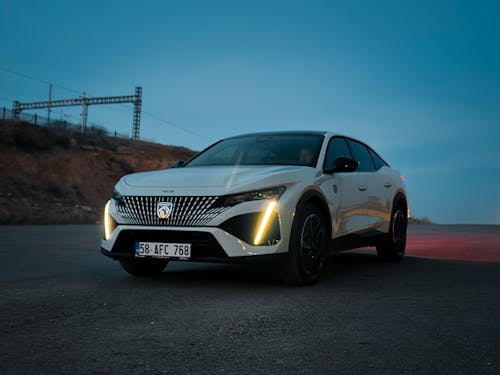 The new peugeot e - car is shown in a dark, empty road