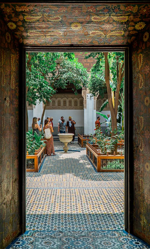 The entrance to a courtyard with people walking through it