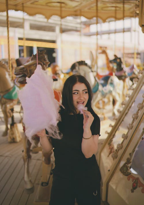 A woman is holding a cotton candy in her hand