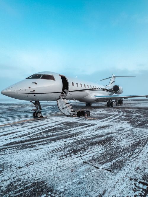 Free Private jet parked on a snowy airport runway during winter, clear sky. Stock Photo