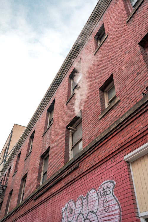 A building with graffiti on it and smoke coming out of it