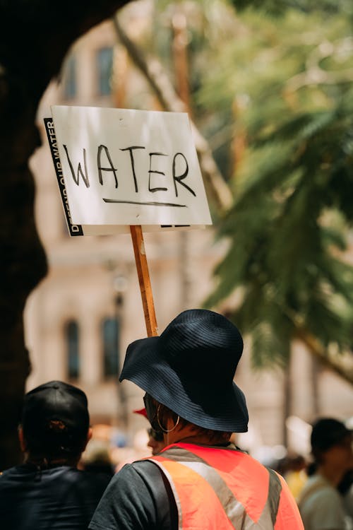 A person holding a sign that says water