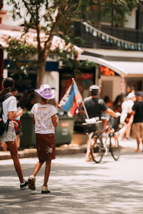 Free Street view of an urban area with people walking and biking on a sunny day. Stock Photo
