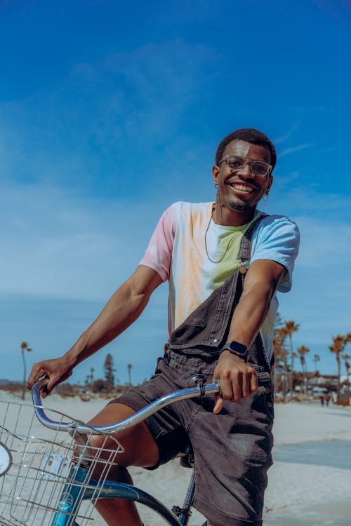 Gratis lagerfoto af afrikansk mand, cykling, grå garnbukser