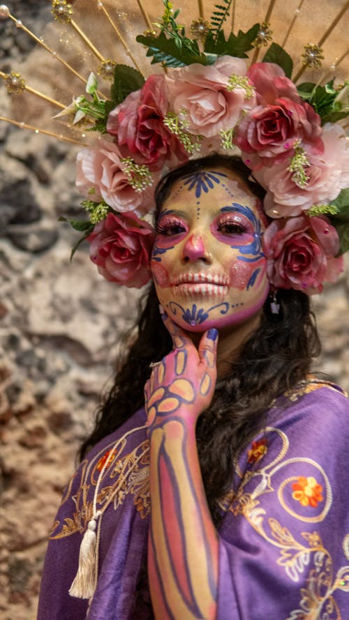 A woman with a skull face paint and flowers on her head