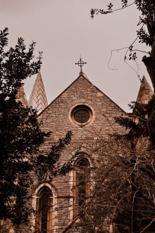 Free Stone church facade in Istanbul surrounded by trees in warm light. Stock Photo