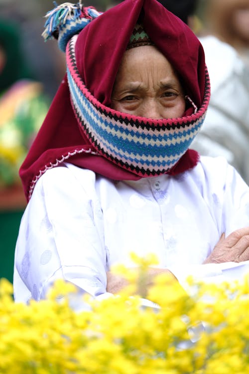 A woman wearing a red and white scarf and a head covering
