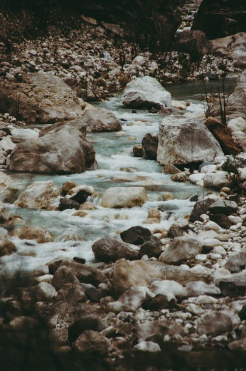 Free Tranquil mountain stream flowing over rocks, capturing nature's purity. Stock Photo