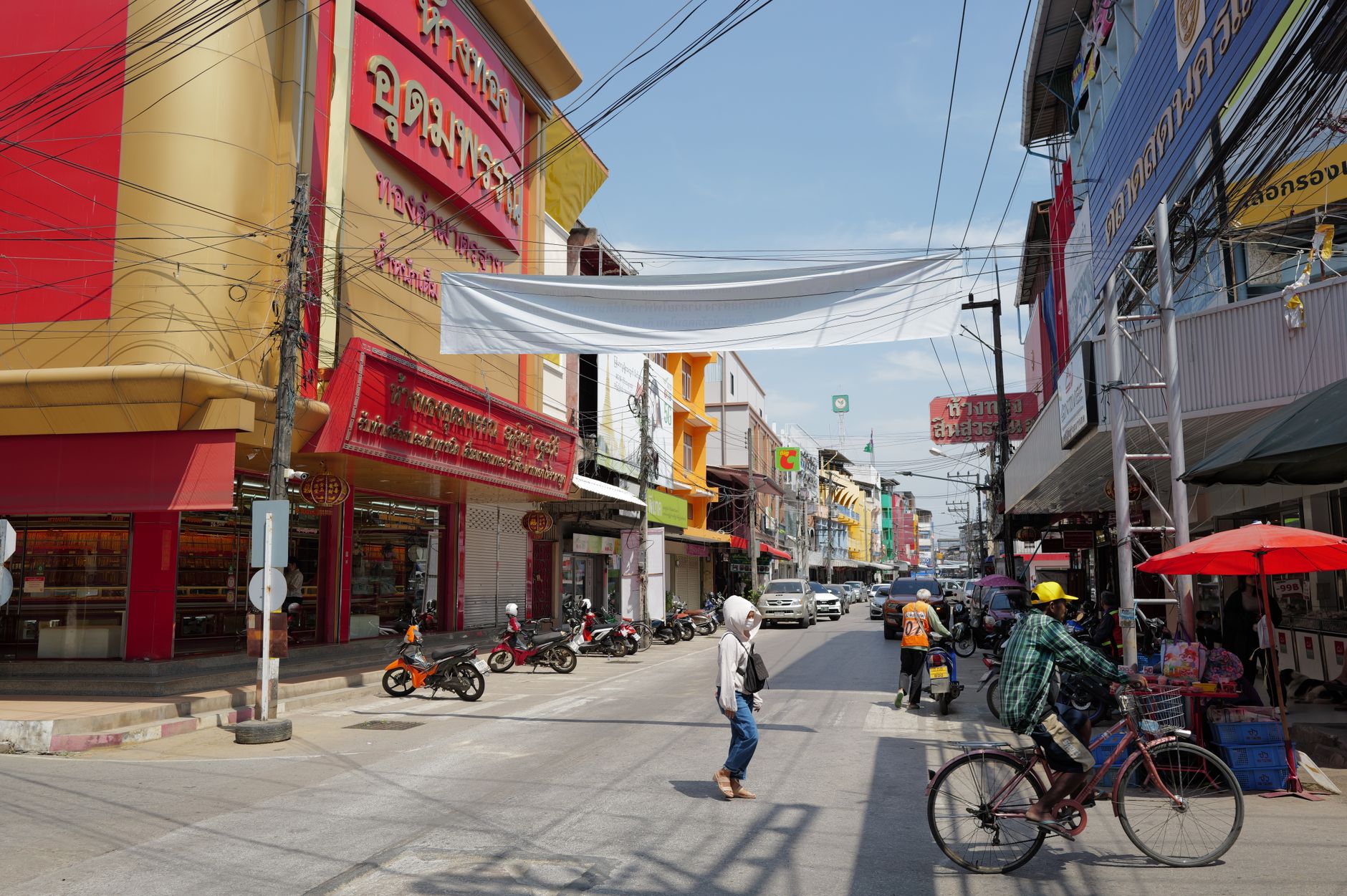 Café-lined street in Ari with young Thais and low-rise buildings