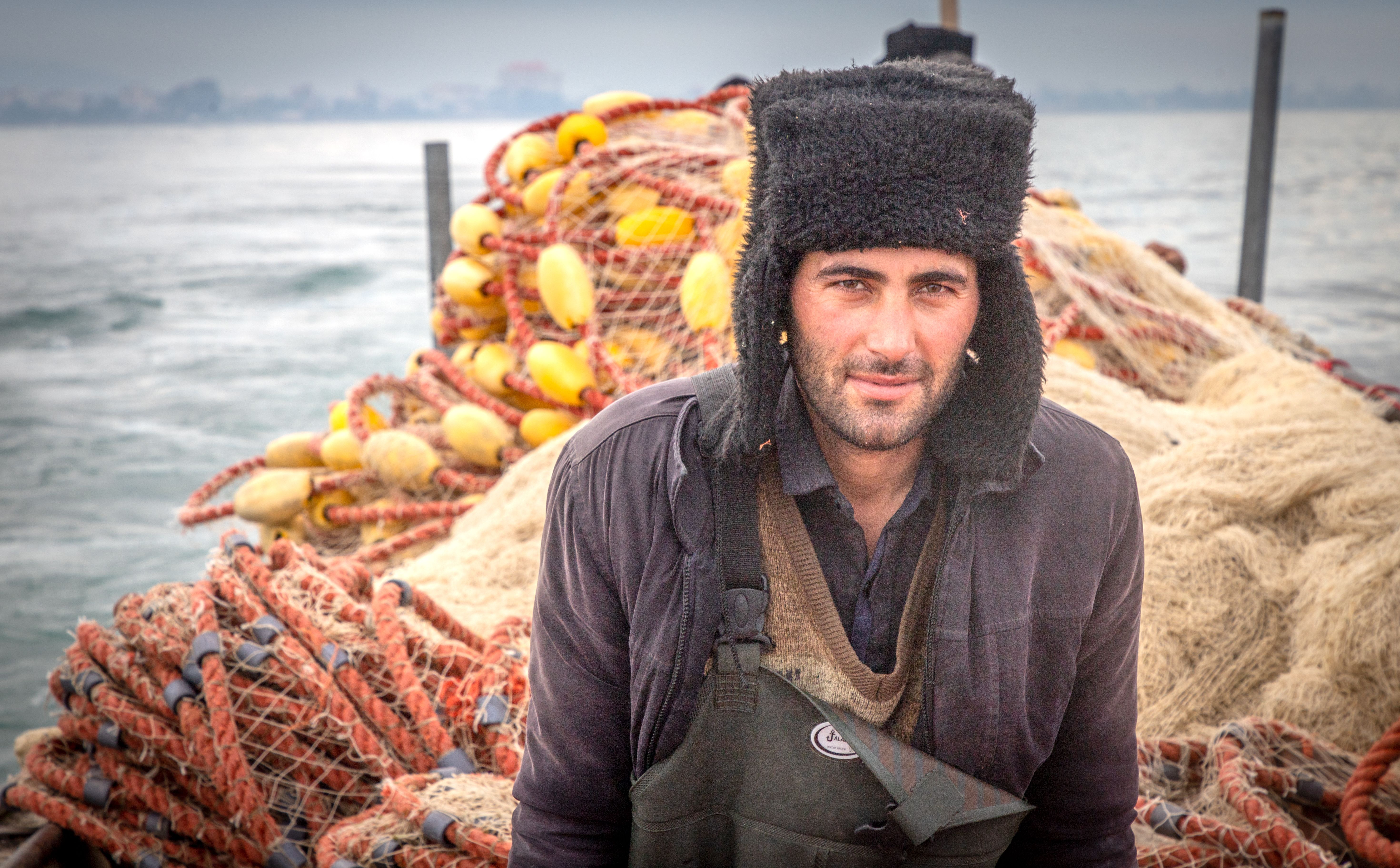 A guide standing among nets and gear on a working boat at sea